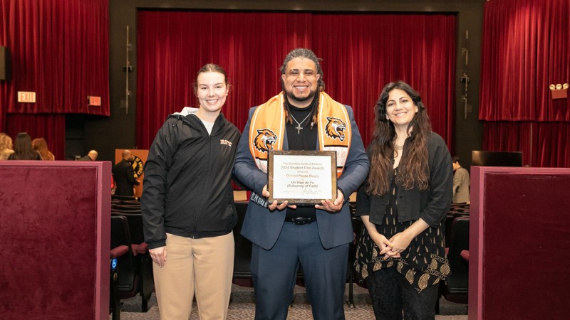 Gabriel Ponte-Fleary holds his DGA award he received alongside a faculty member and ASL interpreter.
