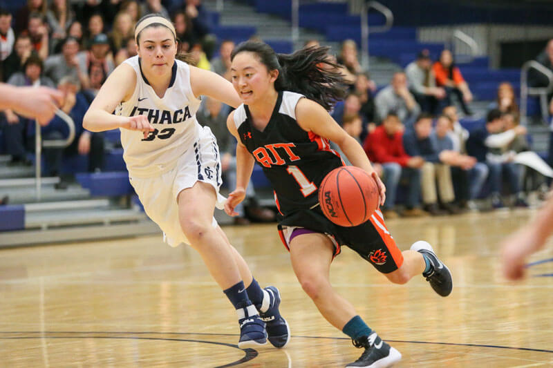 An R I T women's basketball player driving past an opponent.