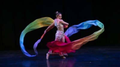 A ribbon dancer dancing on stage during a performance.